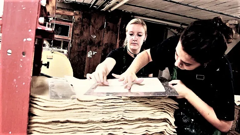 Джулия из Италии и Лаура из Словении осваивают технику изготовления книг в мастерской Анатоля Лютюка.