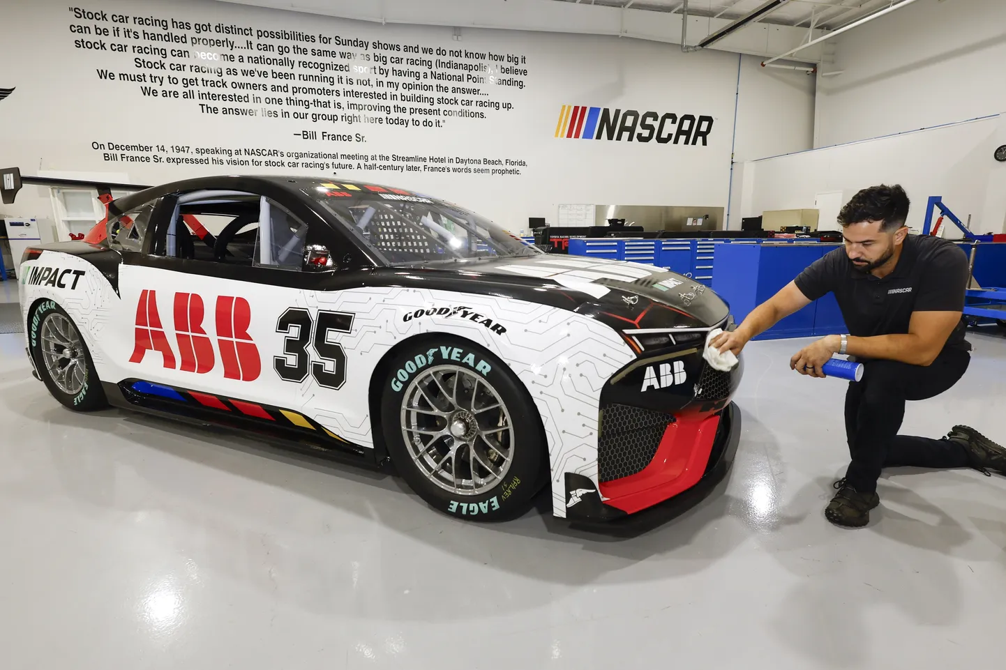 CJ Tobin, senior engineer of vehicle systems, cleans a prototype of the first electric racecar at the NASCAR R&D Center in Concord, N.C., Monday, July 1, 2024. The top motorsports series in North America partnered with Chevrolet, Ford, Toyota and electrification company ABB to demonstrate a high-performance electric vehicle and gauge fan interest in electric racing. (AP Photo/Nell Redmond)  CLI301