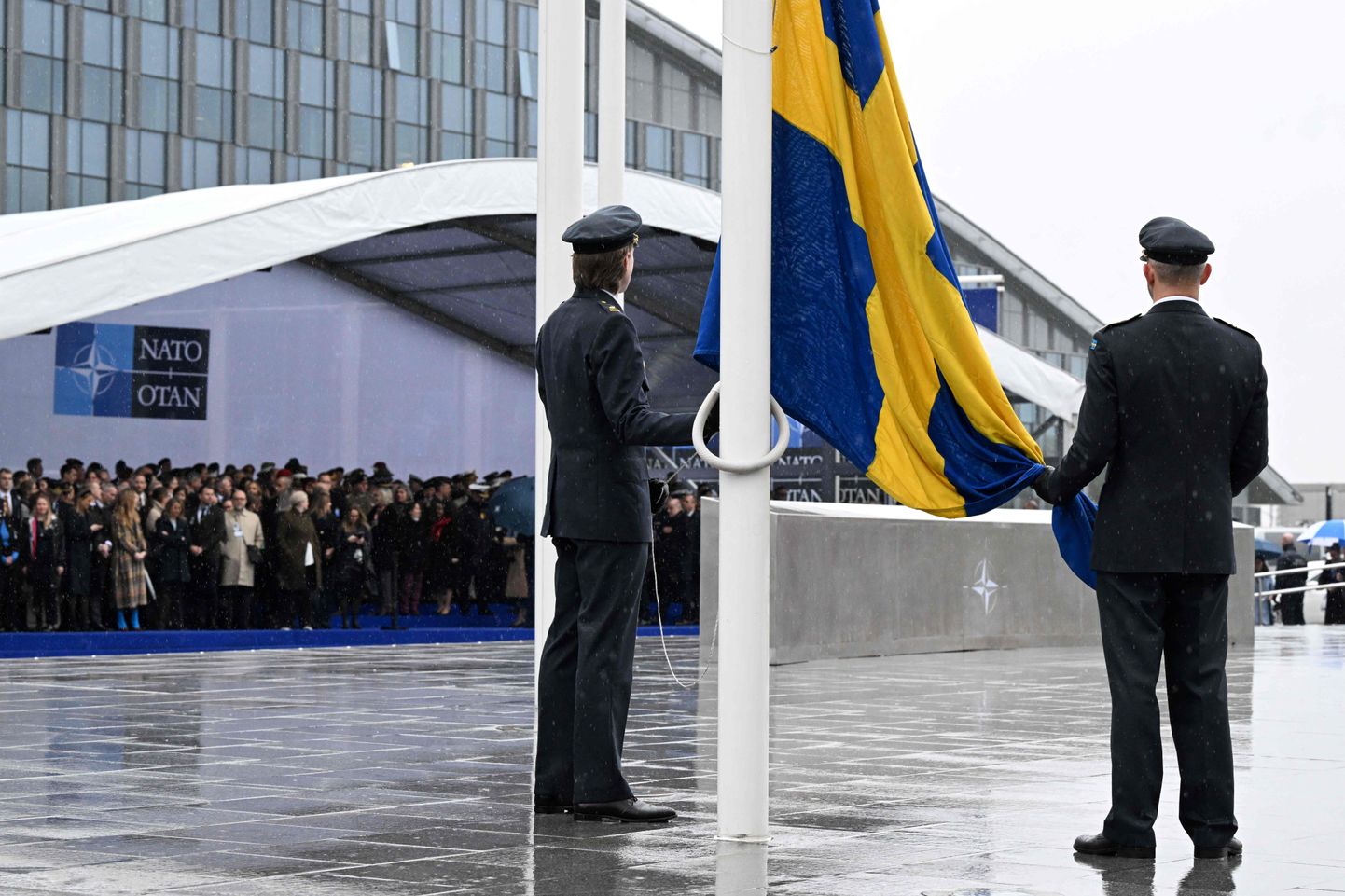 Ametnikud valmistuvad heiskama Rootsi riigilippu 11. märtsil 2024 Brüsselis Põhja-Atlandi alliansi peakorteris toimuval Rootsi NATOga ühinemise lipuheiskamise tseremoonial.