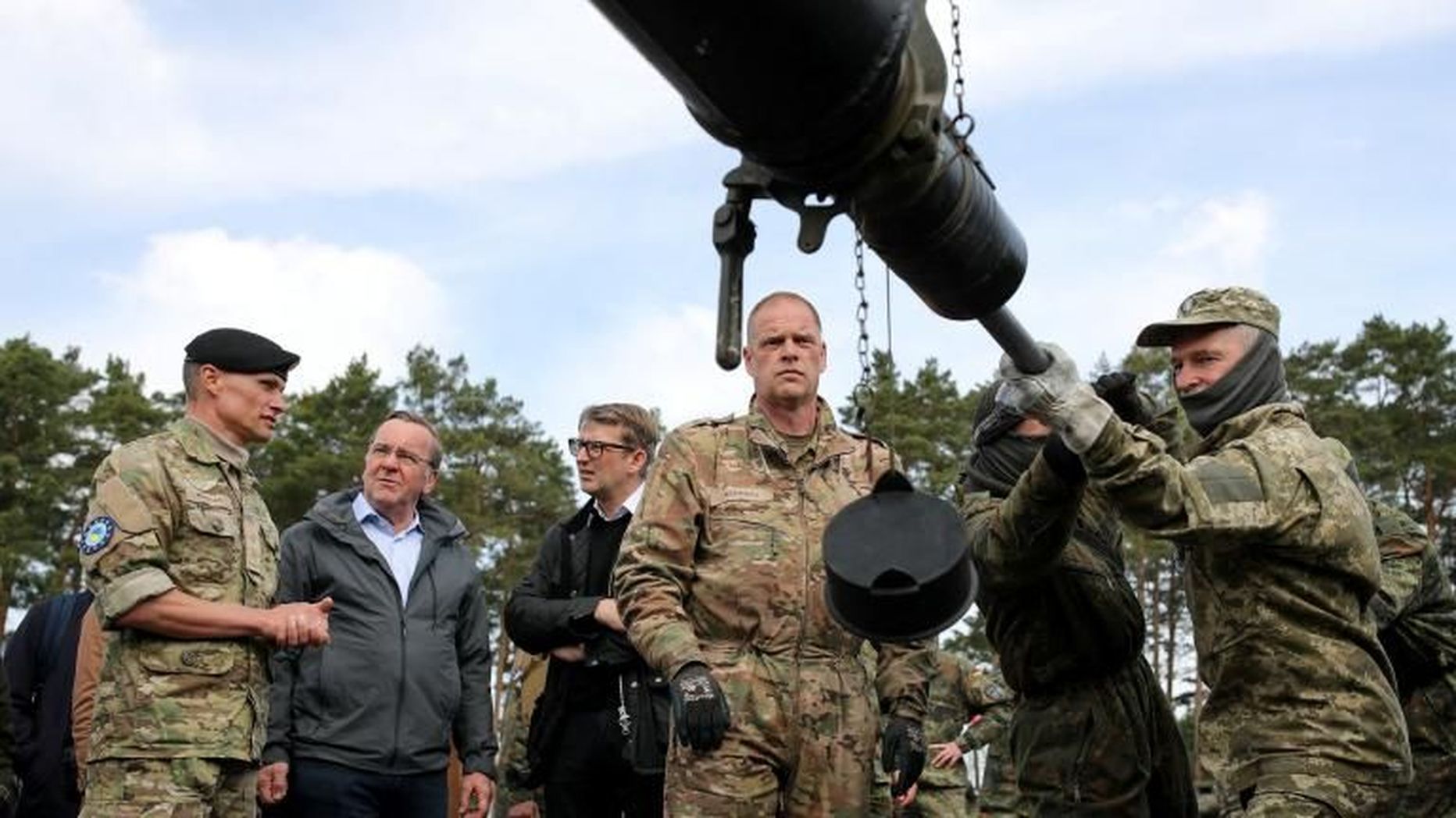 Министр обороны Германии Борис Писториус и и.о. министра обороны Дании Троэлс Лунд Поульсен наблюдают, как украинские солдаты чистят пушку танка Leopard на базе бундесвера.