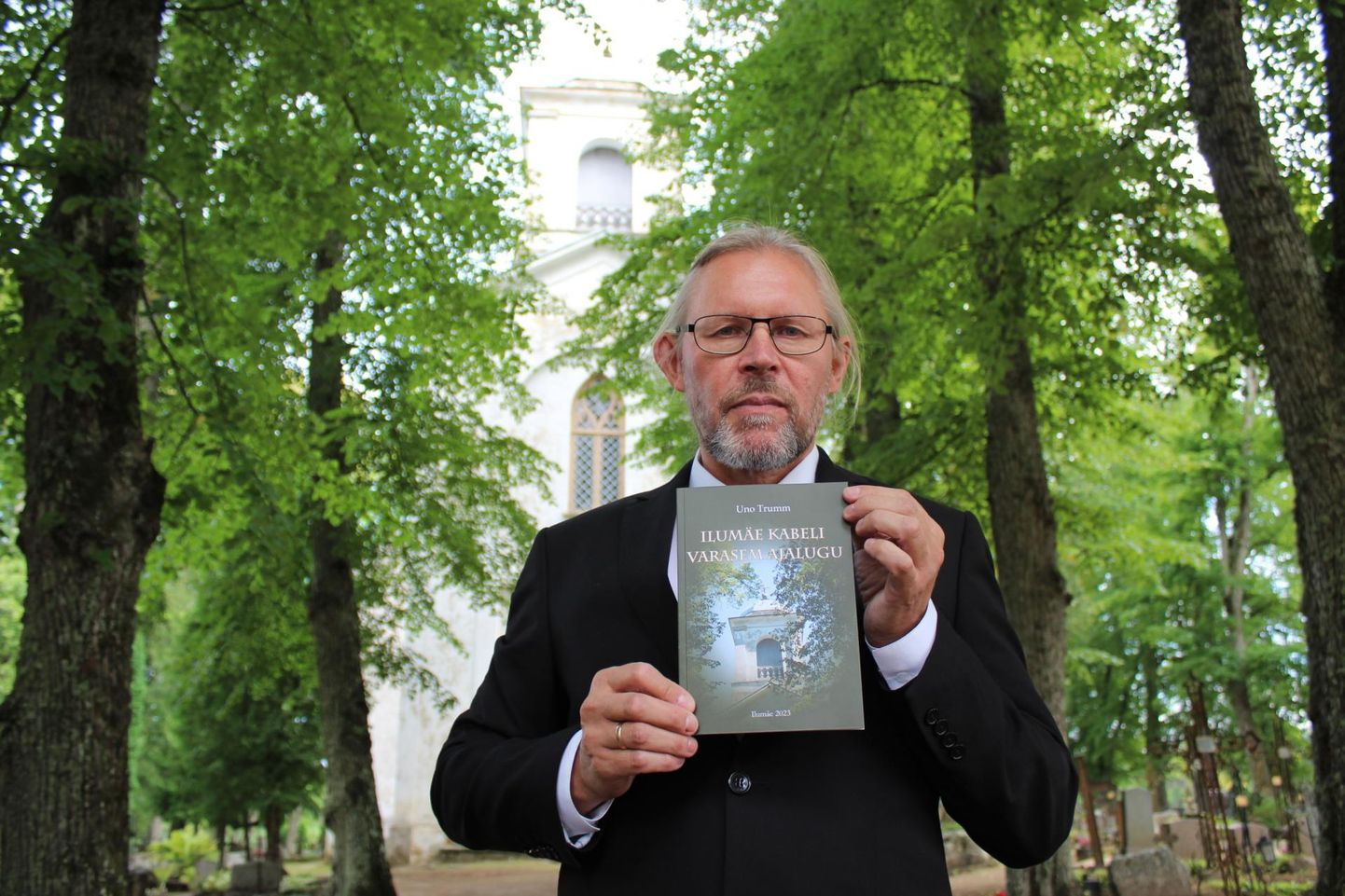 Uno Trumm raamatuga Ilumäe kabeli ees.