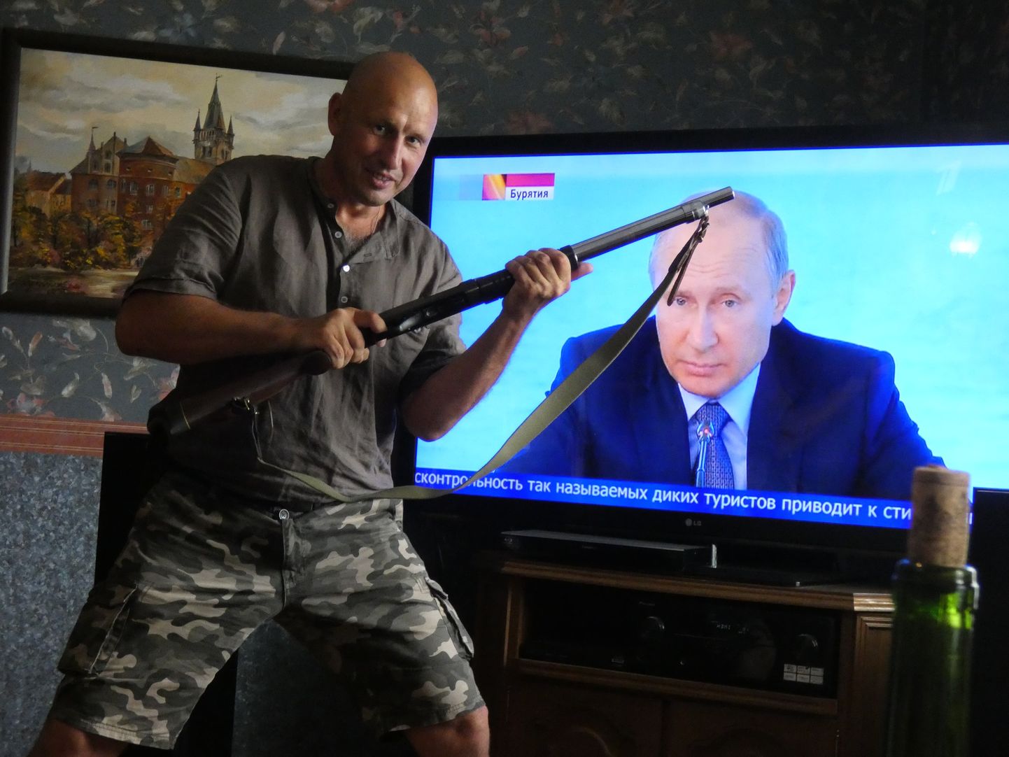 До своего задержания шпионивший на ГРУ Сергей Кондрат позировал в оружием на фоне телевизора, по которому показывали пресс-конференцию президента России Владимира Путина.