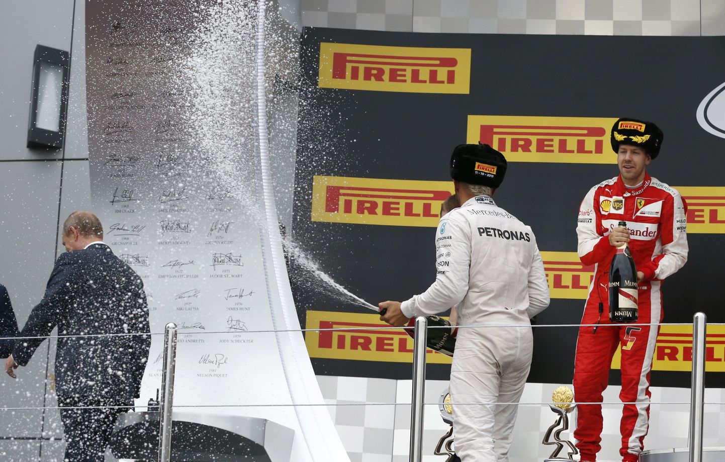 Vladimir Putin (vasakul) lahkumas poodiumilt, kus Lewis Hamilton (keskel, seljaga) šampanjat pritsib.