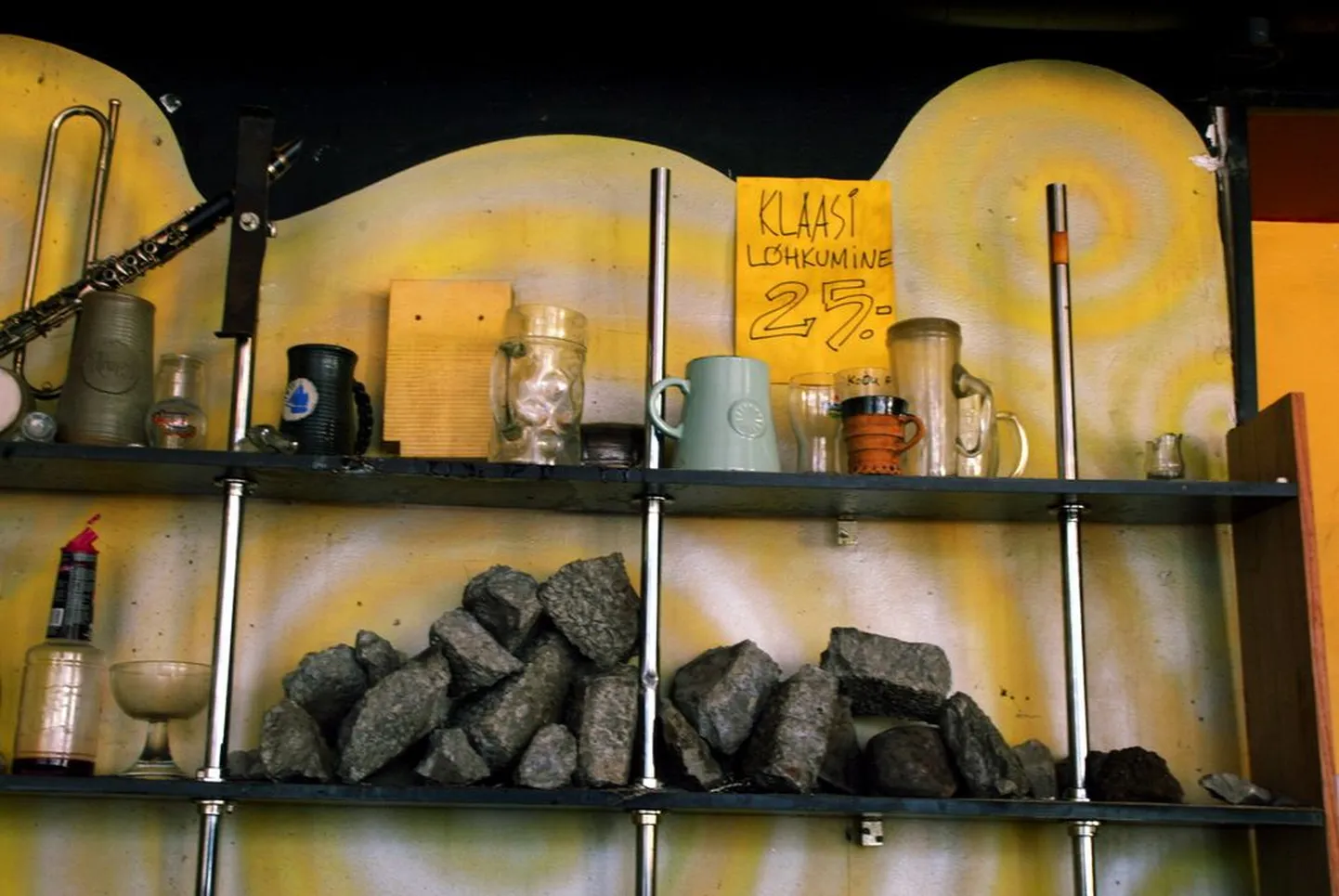 Камни, которые бросали в окна бара Woodstock, популярного среди эстонских националистов, теперь лежат на полке за стойкой бара.