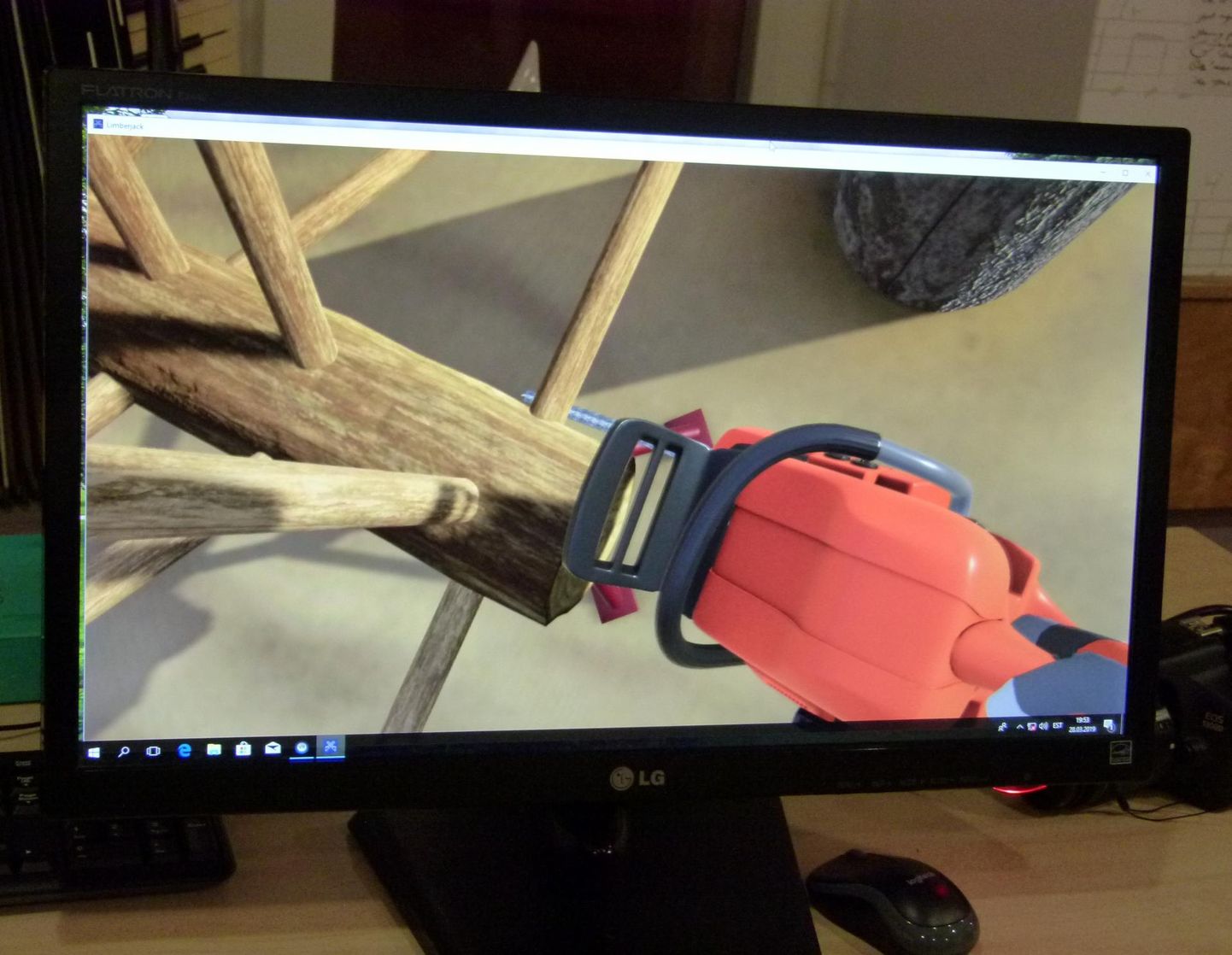 Näide sellest, kuidas mees järkab kolmemõõtmelises maailmas virtuaalset tüve – läbi 3D-prillide näeb ta pilti, mis tegelikult koos saega on kõrval arvutiekraanil.