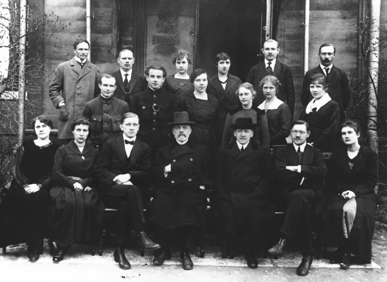 Välisministeeriumi esimene koosseis Väike-Pärnu mnt 3 maja ees sügisel 1919Esimene rida vasakult: Alma Lindpere, Friida Tomson, Aleksander Schipai, välisminister Jaan Poska, Herman Hellat, Nikolai Maim, Helene MüllersteinTeine rida: Jakob Saar, Edurad Hunt, Erika Saler, Marta Johanson, Mary Veldt, Alice Erjapea Kolmas rida: Henrik Sepp, Villem Truve, Margarete Seilman, Hilda Metsis, Eduard Lipso, Johan Lusikas