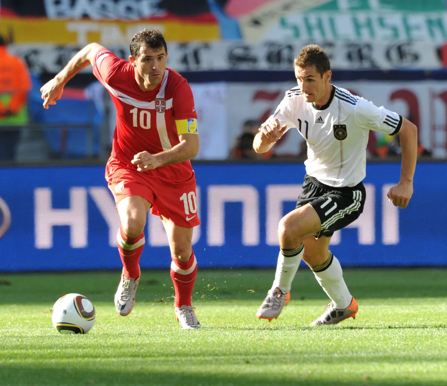 Нападающий сборной Германии Мирослав Клозе (справа) и сербских полузащитник Деян Станкович ведут борьбу за мяч.