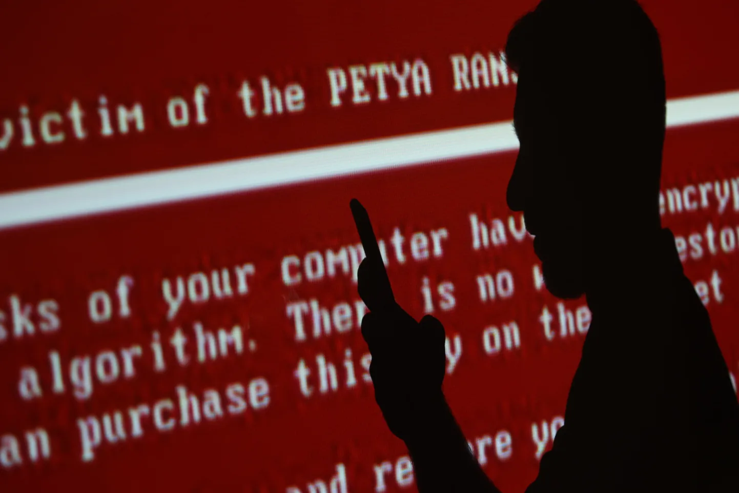 Mees mobiiltelefoniga Petya sõnumi taustal.