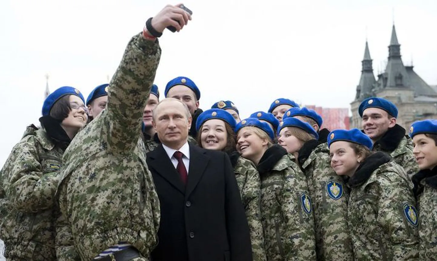 Президент России Владимир Путин делает селфи с участниками военно-патриотического молодежного клуба "Вымпел".