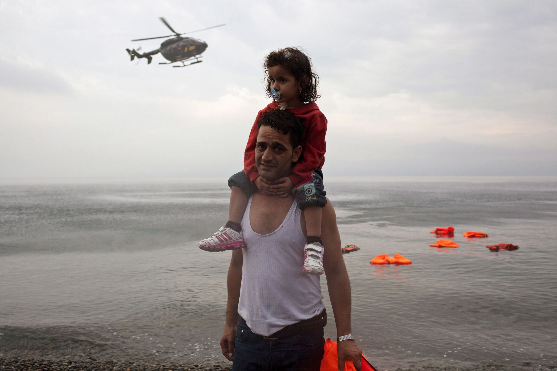 Süüria põgenik Lesbose saarel, taustal Frontexi kopter.