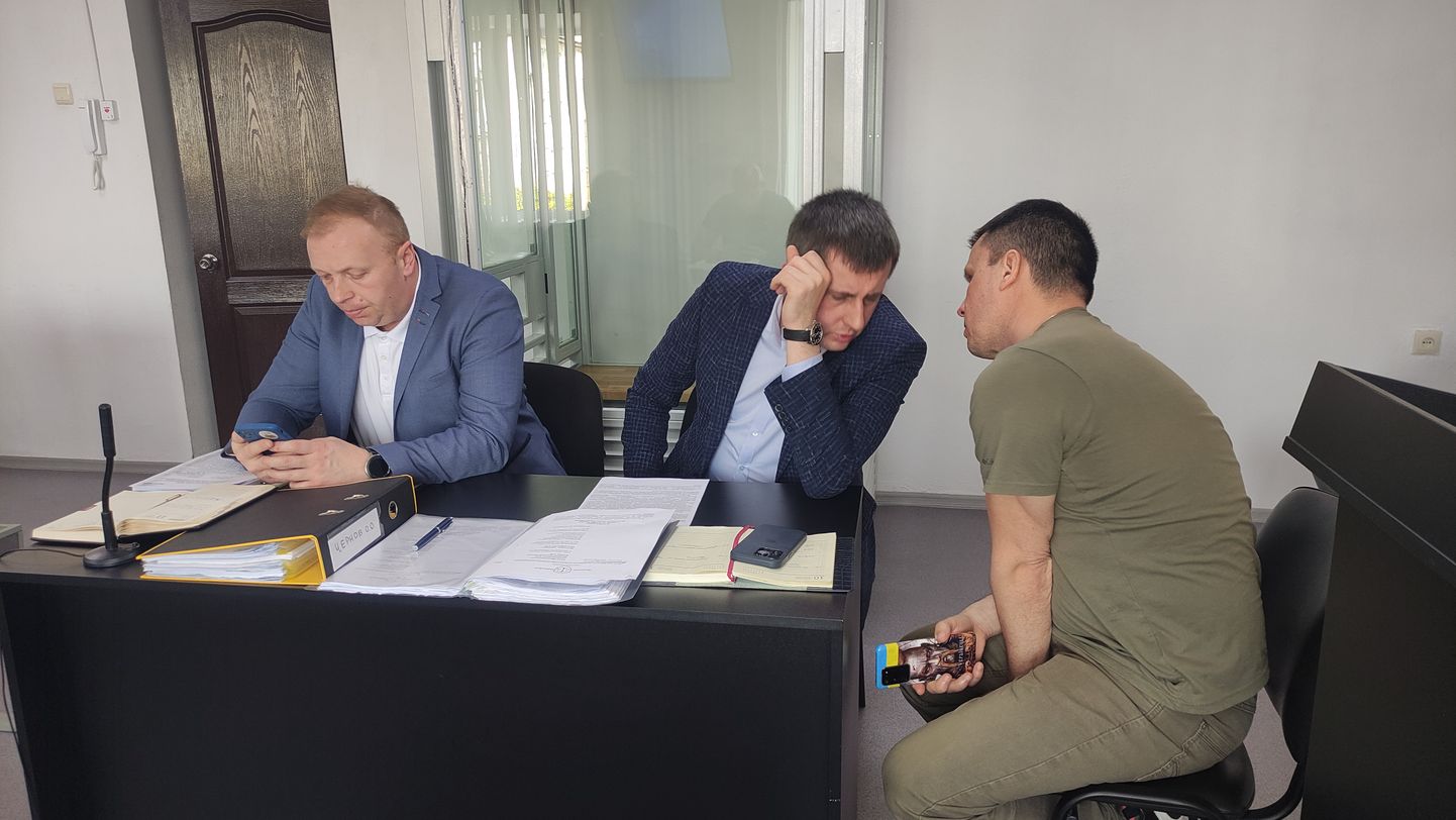Ukraina värvides telefoni käes hoidev Oleksandr Tšernov (paremal) arutamas tänasel istungil midagi oma advokaadi Artem Krasnobrõžõga. Vasakul surfab telefonis tema teine advokaat Vadõm Maltsev.