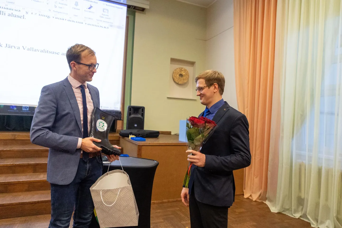Uut vallavanemat kingikotiga õnnitlenud volikogu esimees Rait Pihelgas (vasakul) ütles, et teab oma vallavanema ajast, et Järva vallavanem ei saa käia tööl ülikonnas, vaid rohkem läheb tarvis kummikuid, sest vahel tuleb ka memmedele puid saagima minna.