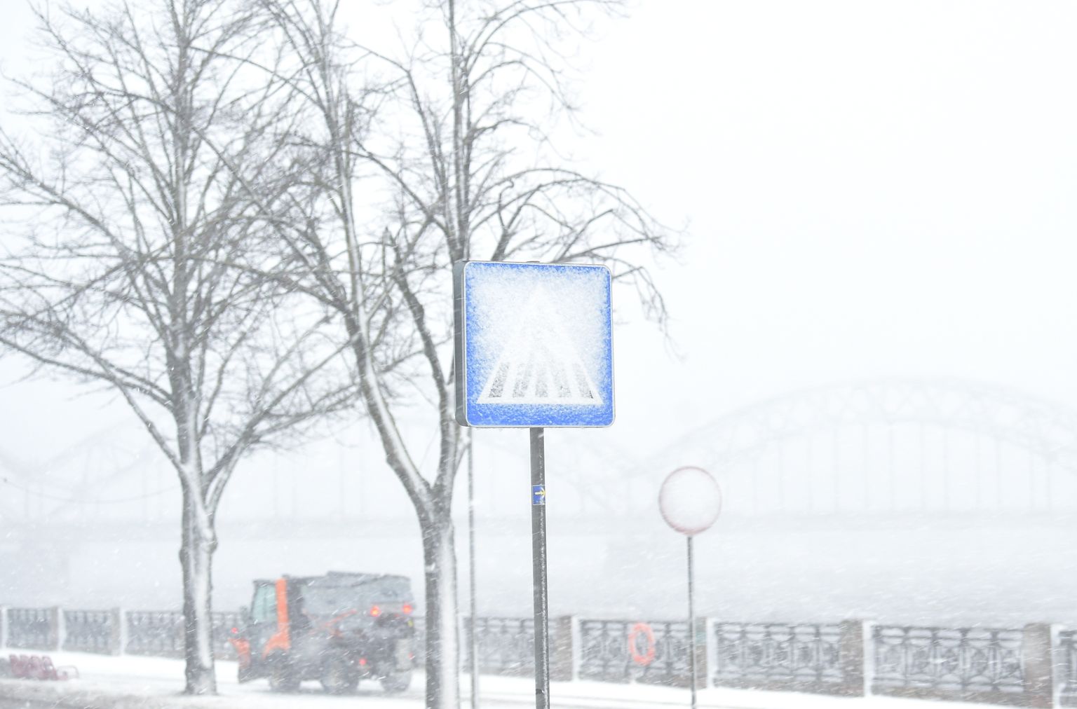 Pilsētā plosās sniegputenis un spēcīgs vējš, kas brāzmās pastiprinās līdz 33 metriem sekundē.