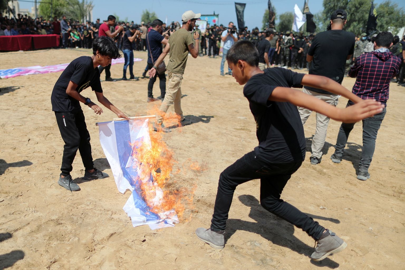 Noored palestiinlased Islamidžihaadi sõjaväelaagris Iisraeli lippu põletamas.
