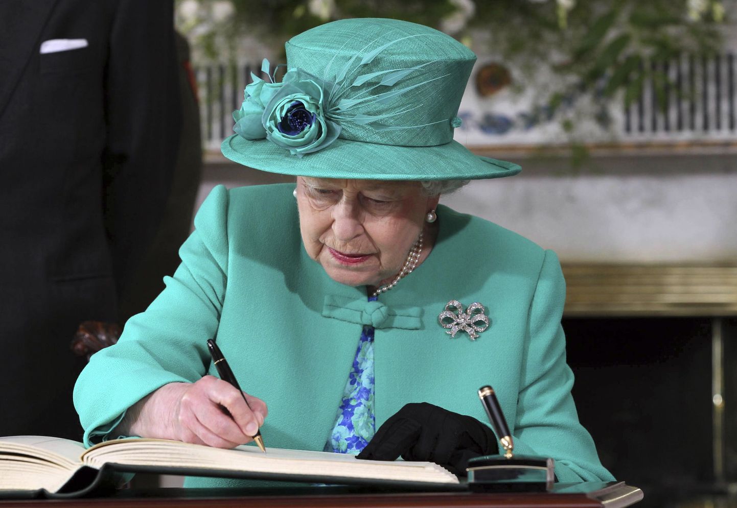 Королева Елизавета подписывает важные бумаги.