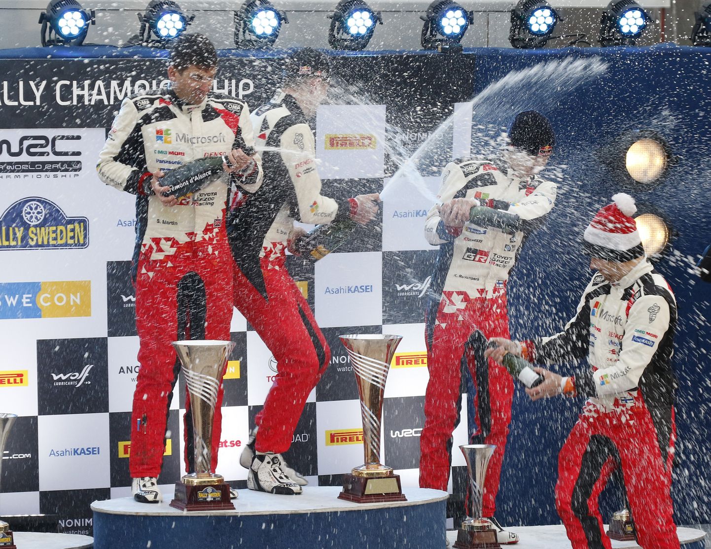 Toyota tiimi rallisõitja Elfyn Evans ja kaardilugeja Martin Scott kallavad Rootsi ralli võitu tähistades šampanjaga üle tiimikaaslased Kalle Rovanperä ja Jonne Halttuneni.