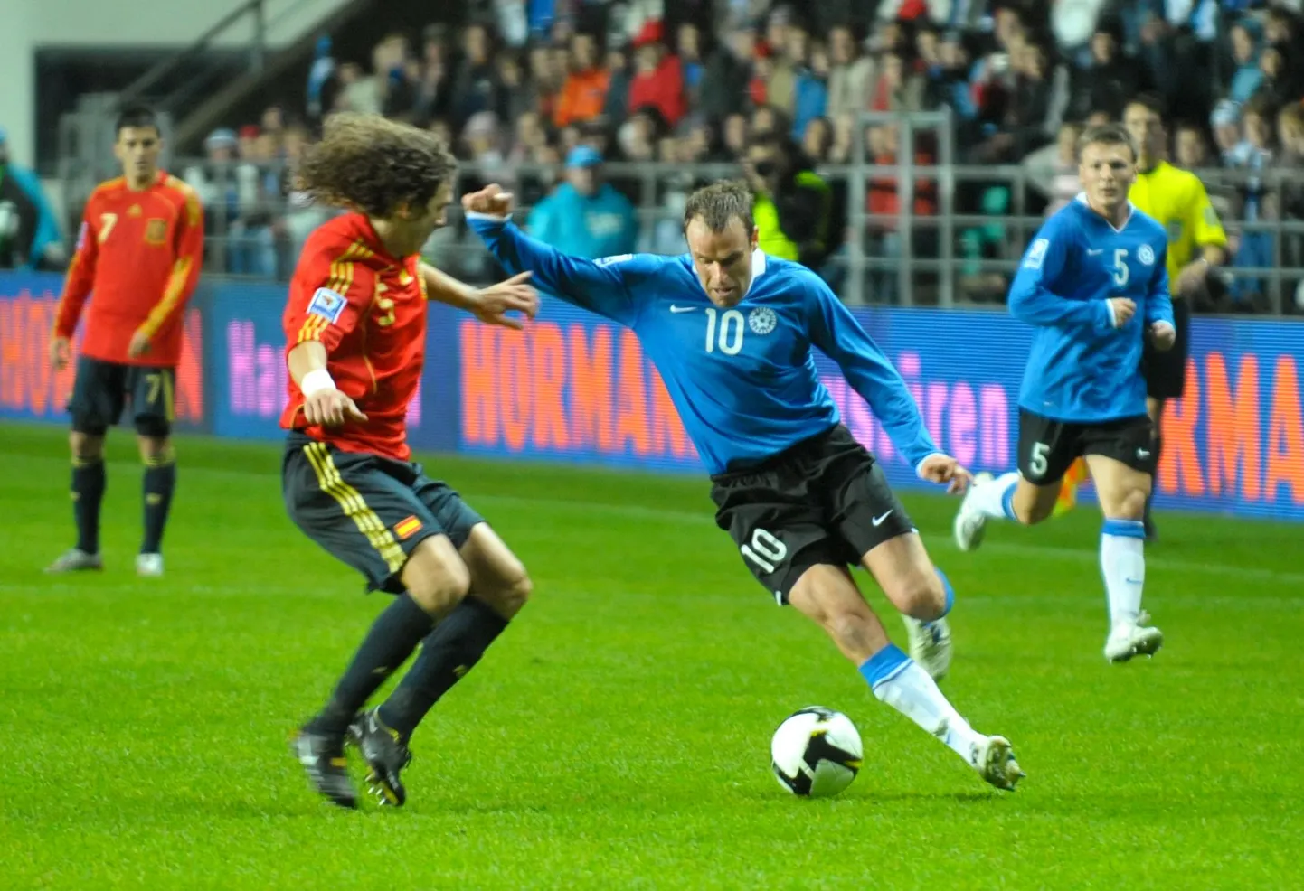 Joel Lindpere (palliga) võtab mõõtu Hispaania koondise kaitseässalt Carles Puyolilt.