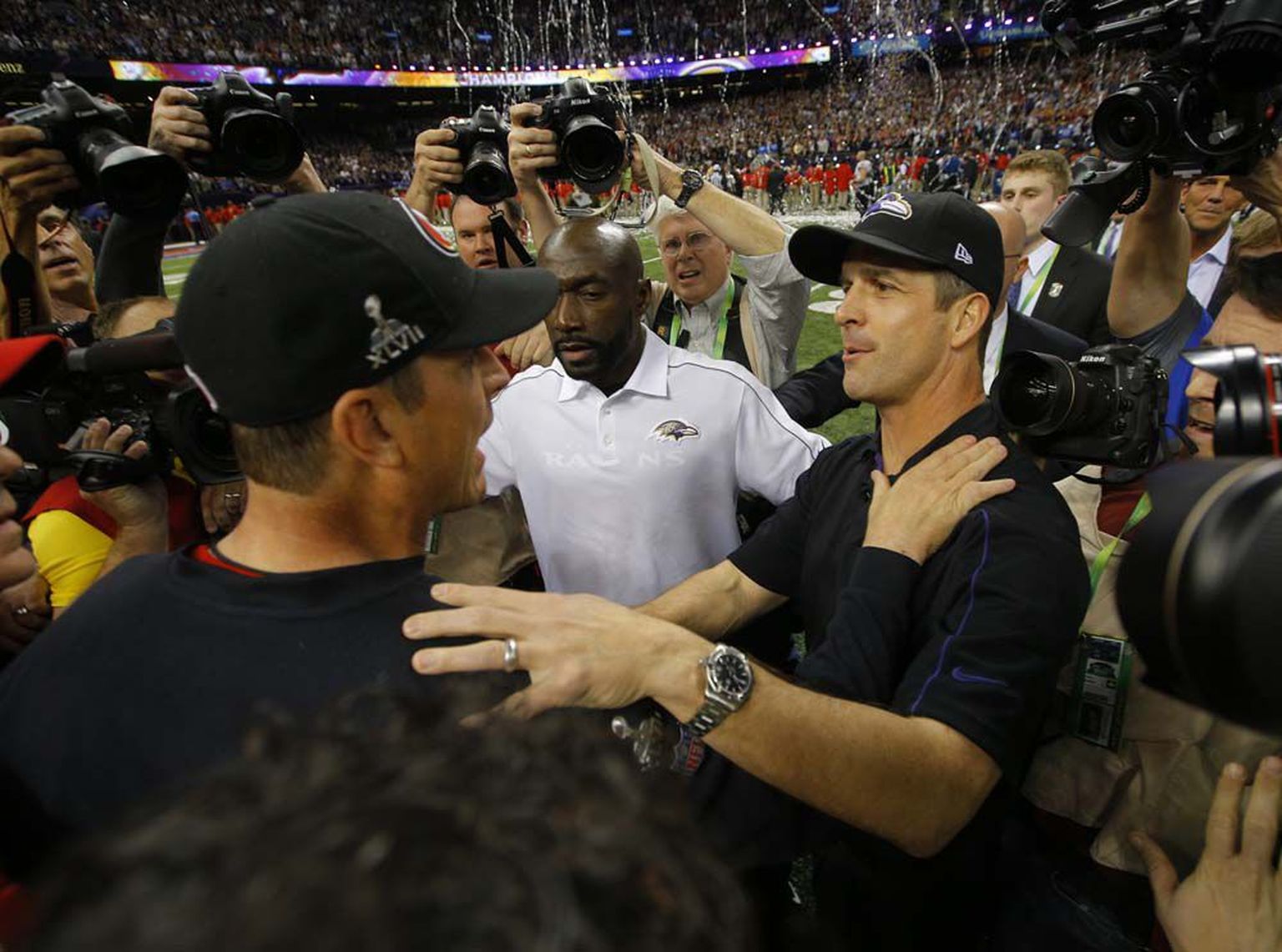 San Francisco 49ers'i peatreener Jim Harbaugh (vasakul) õnnitlemas oma venda ja vastasmeeskonna juhendajat John Harbaugh'i võidu puhul.