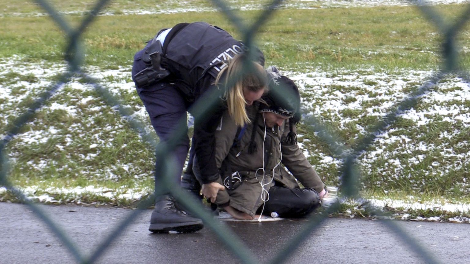 Saksa politseinik üritab viia eemale keskkonnaaktivisti Berliini lennujaamas 8. detsember 2022.