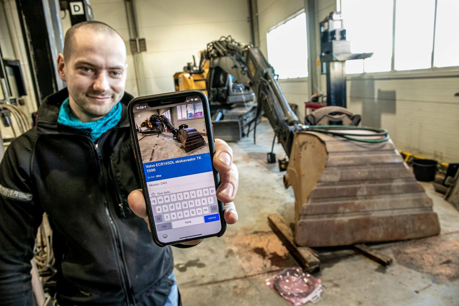 Auto Lüliti OÜ töökoja meister Karl Pikla näitab oma nuti­telefoni abil, kuidas käib töö tänapäevases ja keskkonnasäästlikult mõtlevas ettevõttes.