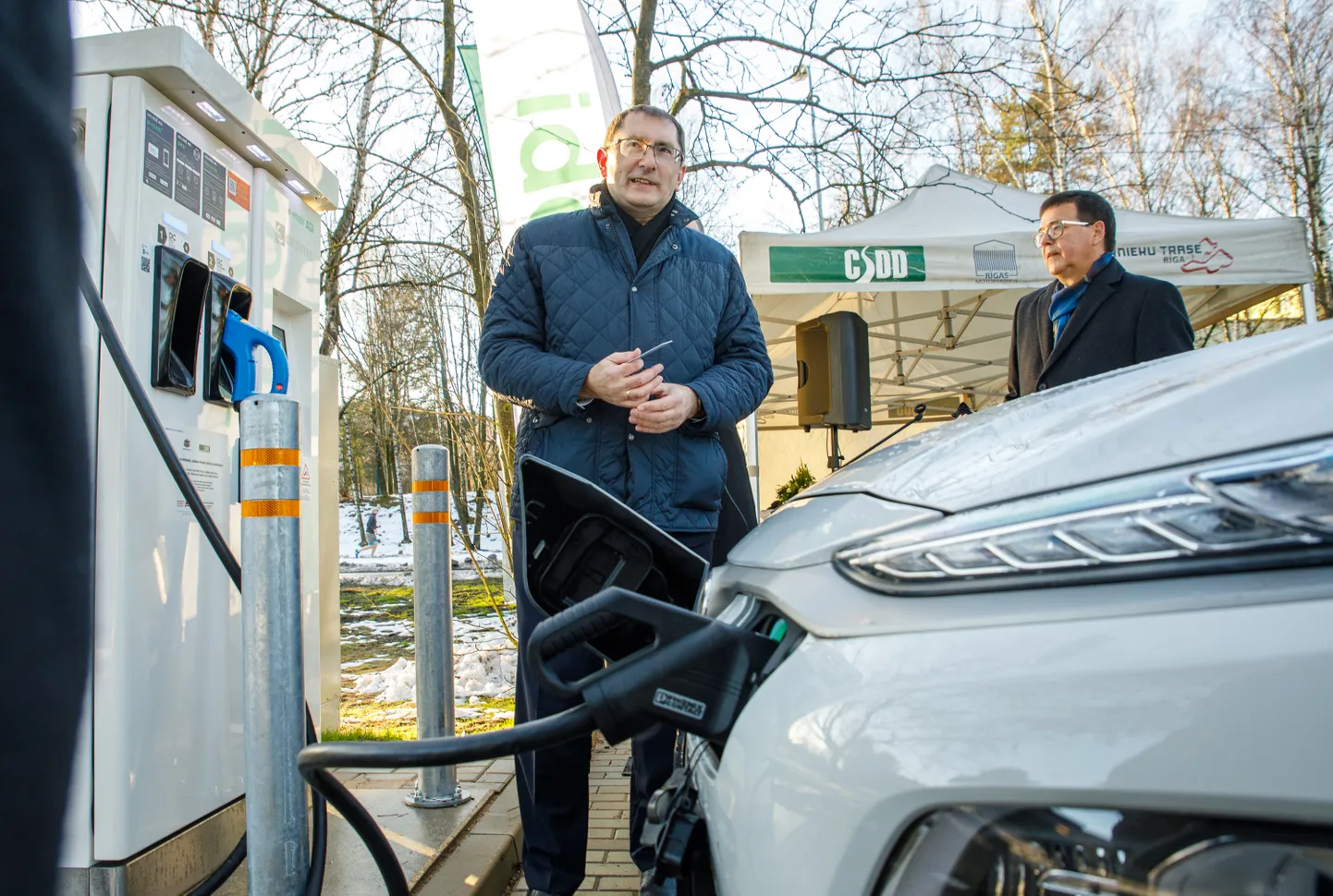 Satiksmes ministrs Tālis Linkaits elektroauto uzlādes punkta atklāšanā Ziemeļblāzmas dzelzceļa stacijā