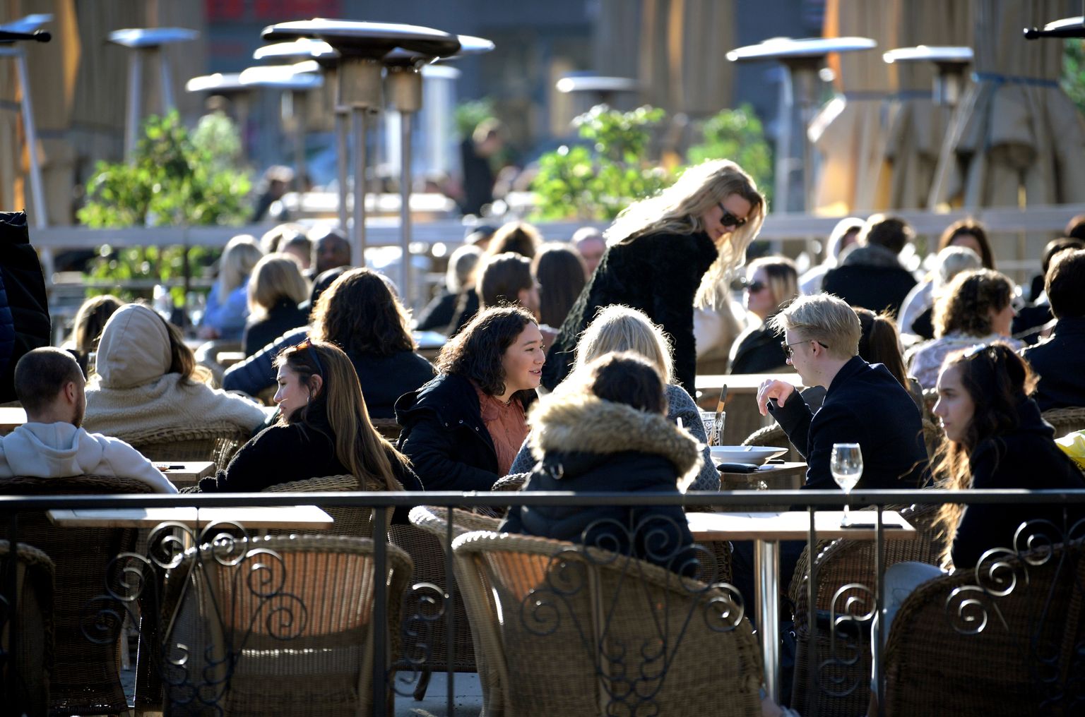 Välikohvik Rootsis Stockholmis, kus inimesed koroonapandeemiast hoolimata ilusat ilma, sööki ja jooki naudivad