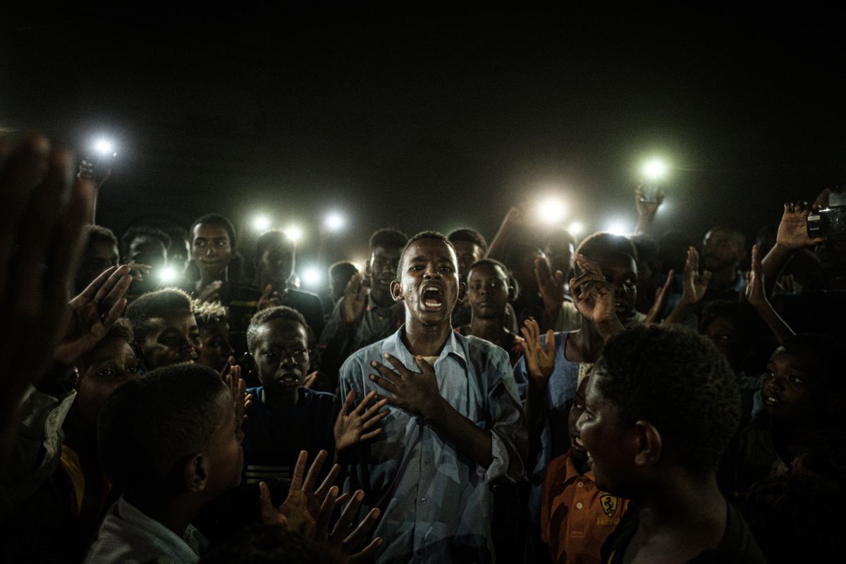 Elektrikatkestuse ajal mobiiltelefonide valguses luulet lugevat noort meest saadavad  meeleavaldajate üleskutsed tsiviilvalitsuse moodustamisele. Hartum, Sudaan, 19 juuni 2019.