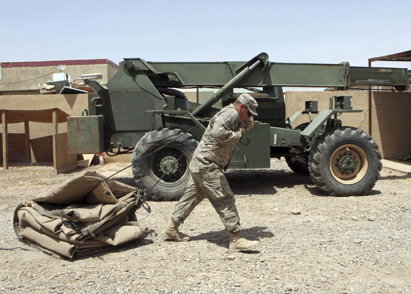 Iraagist lahkuma valmistuvas üksuses teeniv ameeriklane lohistamas Bagdadi baasis kokku pandud telki.
