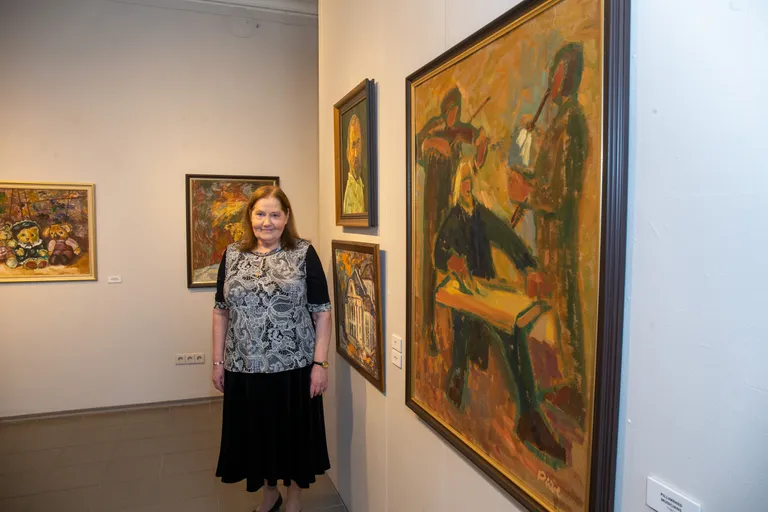 Piibe Arrak oma näitusel, esiplaanil maal «Pillimehed» aastast 1963.