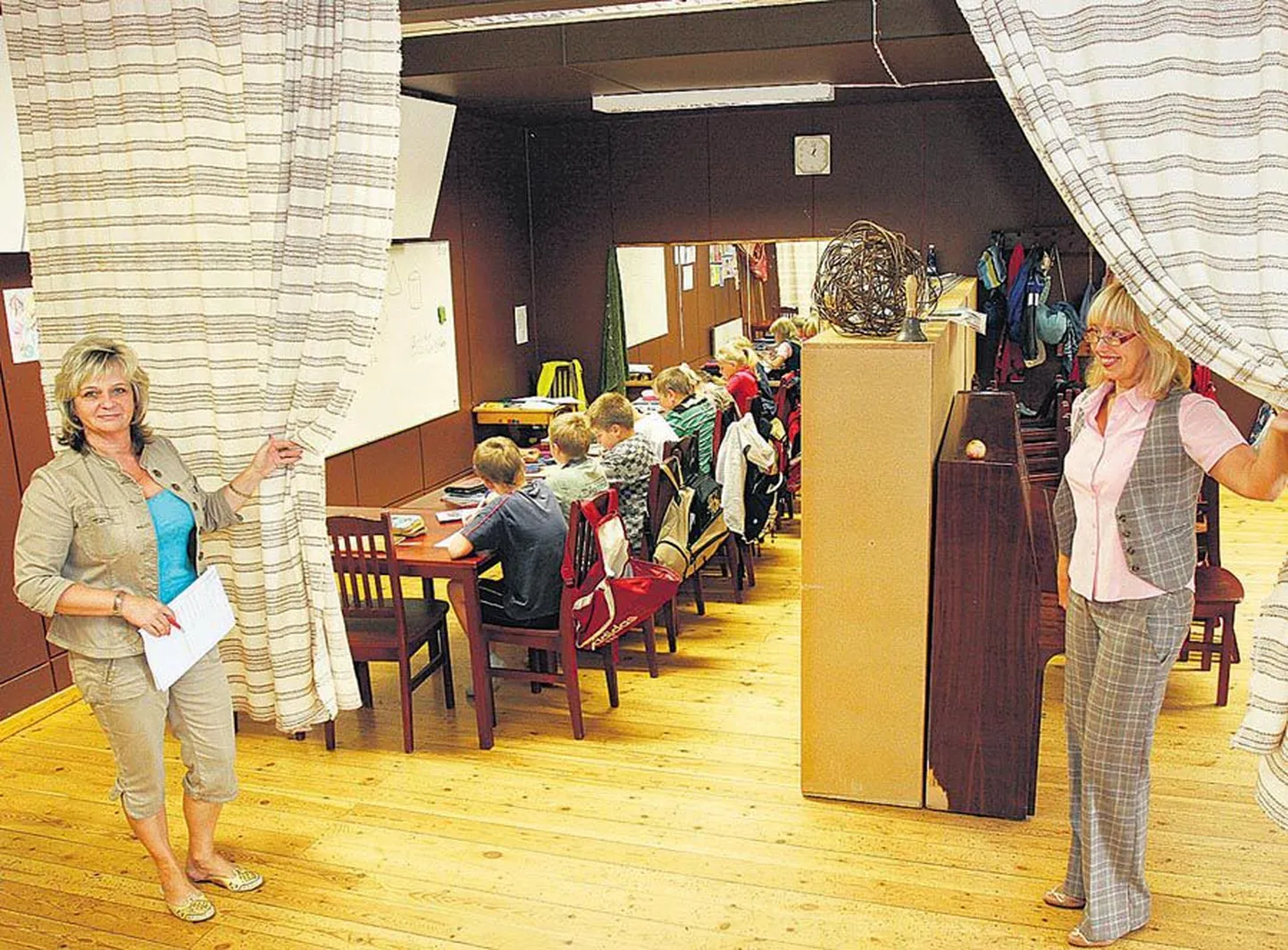 Eile Kalmetu rahvamajas III klassile matemaatikat õpetanud Tiiu Edo (vasakul) ja õppejuhataja Heljo Saar näitavad ajutist kardinatagust klassiruumi.
