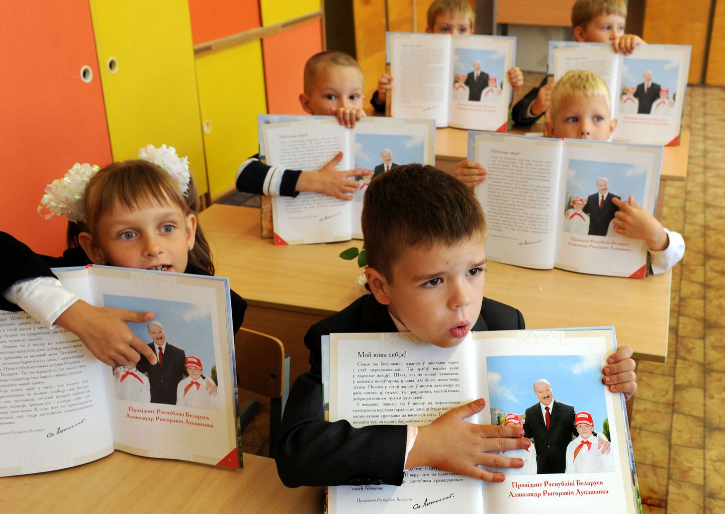 Valgevene esimese klassi õpilased lugemikust president Aleksandr Lukašenka pilti demonstreerimas.
