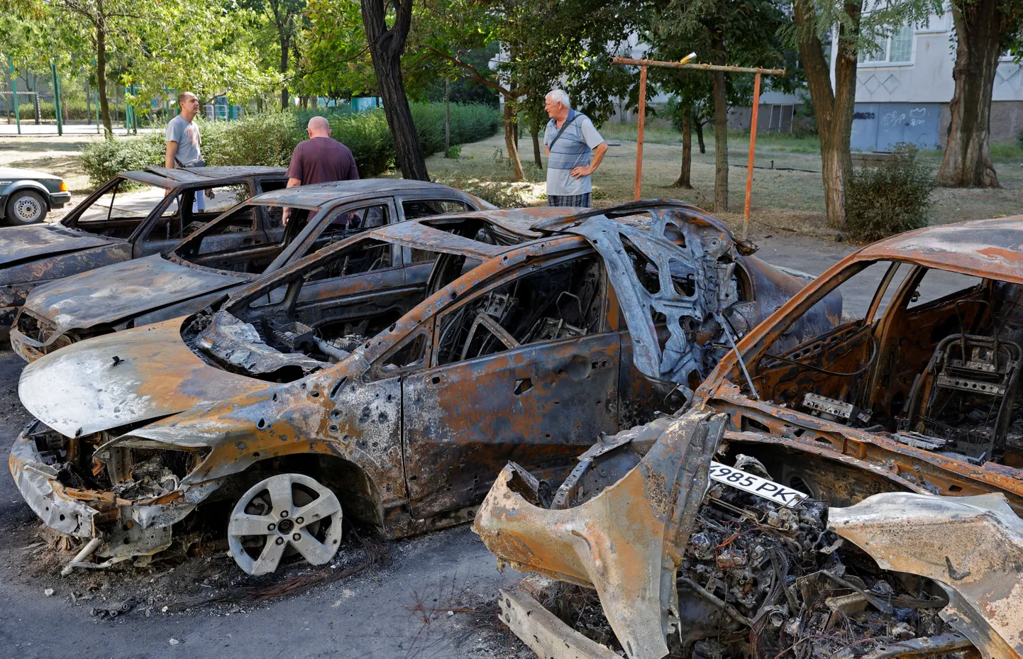 Kohalikud elanikud uurimas hiljutiste raketirünnakute käigus hävitatud autosid Venemaa kontrolli all olevas Enerhodari linnas 30. augustil.
