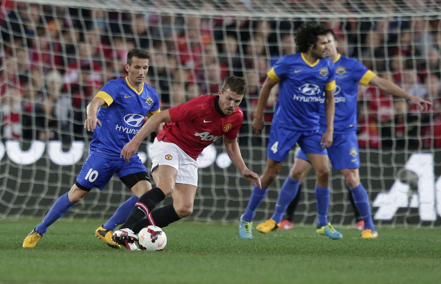 Manchester United Michael Carrick, second from left, steals the ball off Sydney Allstars' Liam Miller, left,during a exhibition match in Sydney, Australia, Saturday, July 20, 2013.(AP Photo/Rob Griffith) / SCANPIX Code: 436