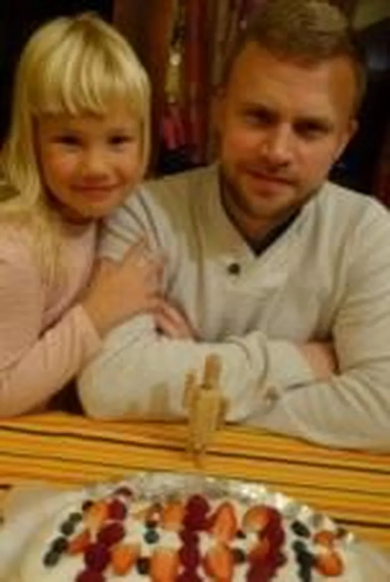 Leiutaja Greta ja juhendaja Margus, nende ees käsitööna valminud puitmudel algkoolilapse hoidjast-robotist.