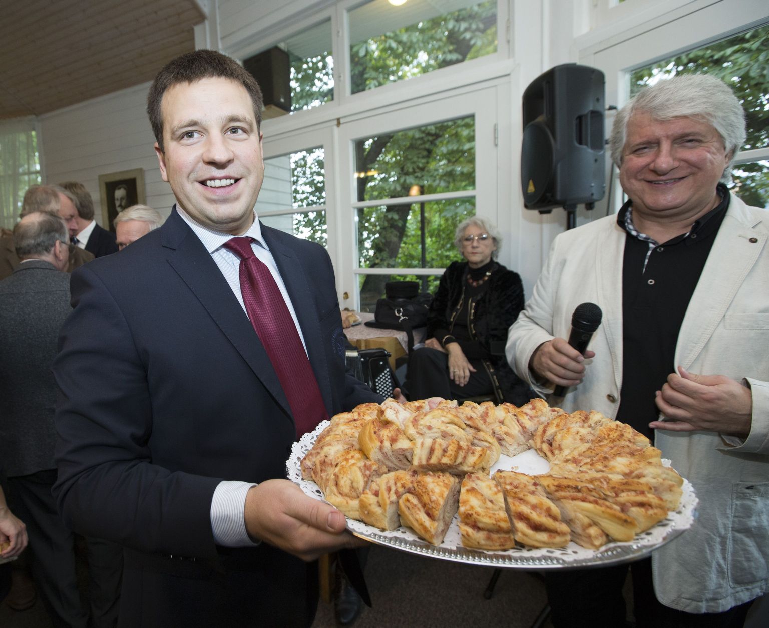 Keskerakonna sünnipäev Harju mäel Edgari kohvikus. Pildil Jüri Ratas jagab peo külalistele kringlit, kõrval näitleja Eduard Toman.