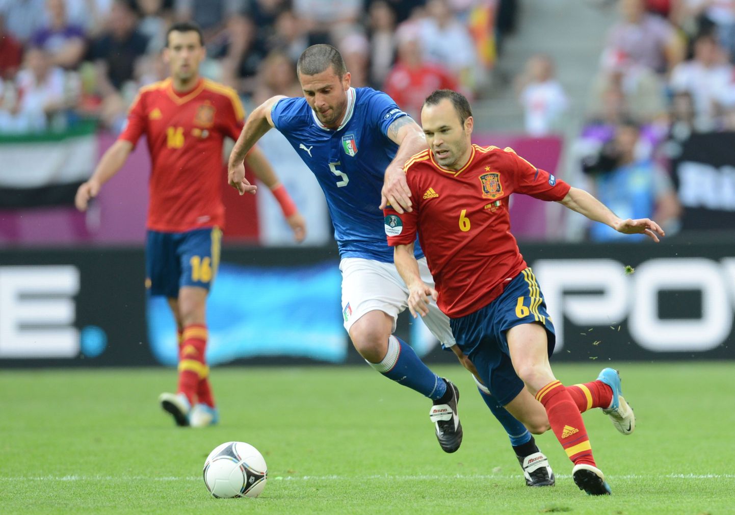 Лидер сборной Испании Иньеста (справа) борется за мяч с итальянцем Тиаго Мотта.