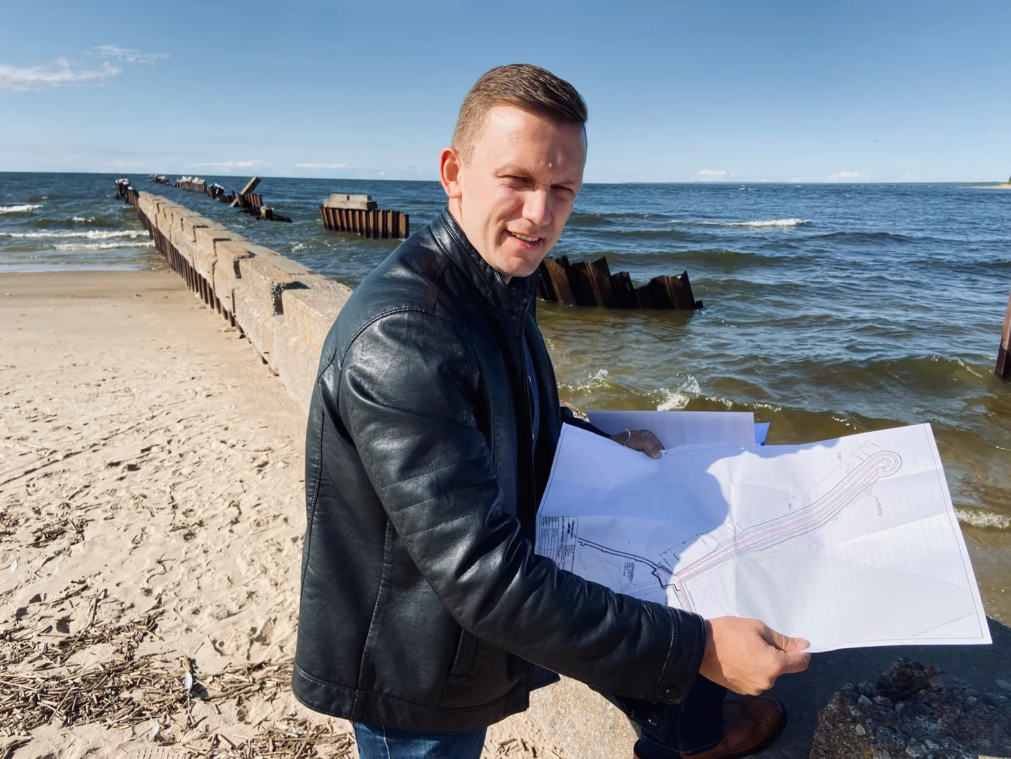 Narva-Jõesuu linnapea Maksim Iljin uue muuli projektiga vana ja poollagunenud muuli ääres.