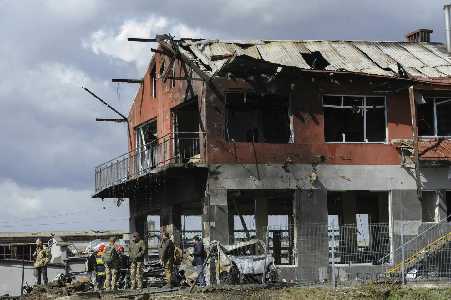 Ukraina päästetöötajad eile seismas purustatud rehvitöökoja juures.