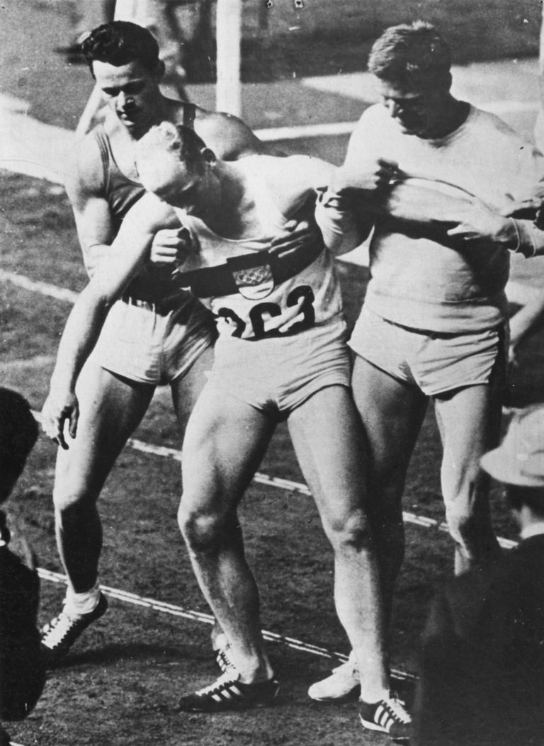 Kuulus hetk Tokyo olümpialt: eestlane Rein Aun (vasakul) ja sakslane Horst Beyer toetavad 1500 meetri jooksu finišis kurnatud olümpiavõitjat Willi Holdorfi.