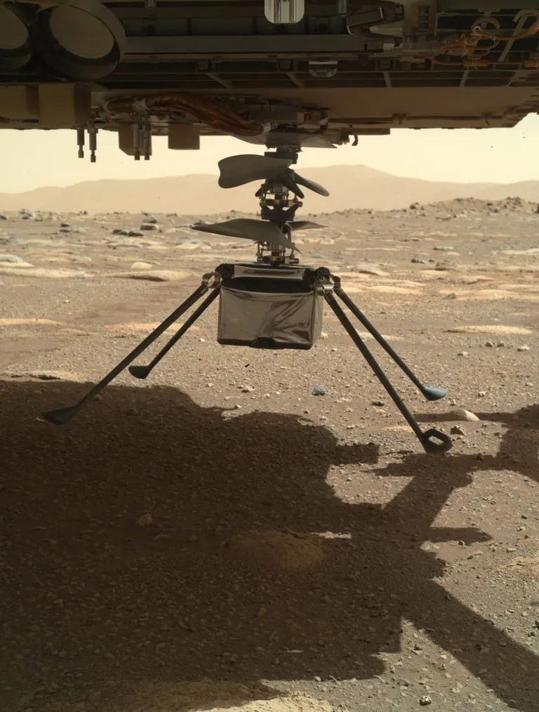 NASA avaldatud foto, millel on näha minihelikopterit Ingenuity laskumas Marsi pinnale kulgur Perseverance'i seest