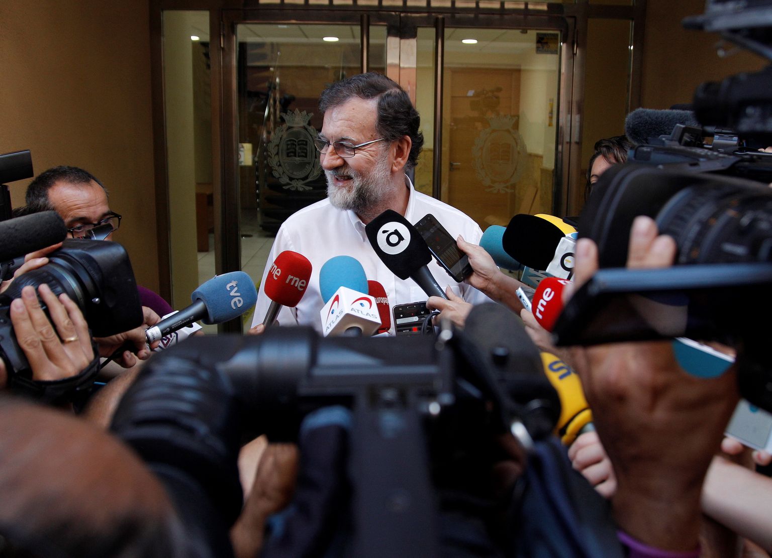 Hispaania endine peaminister Mariano Rajoy vestlemas ajakirjanikega enne esimest tööpäeva Santa Pola linna kinnisvararegistris.