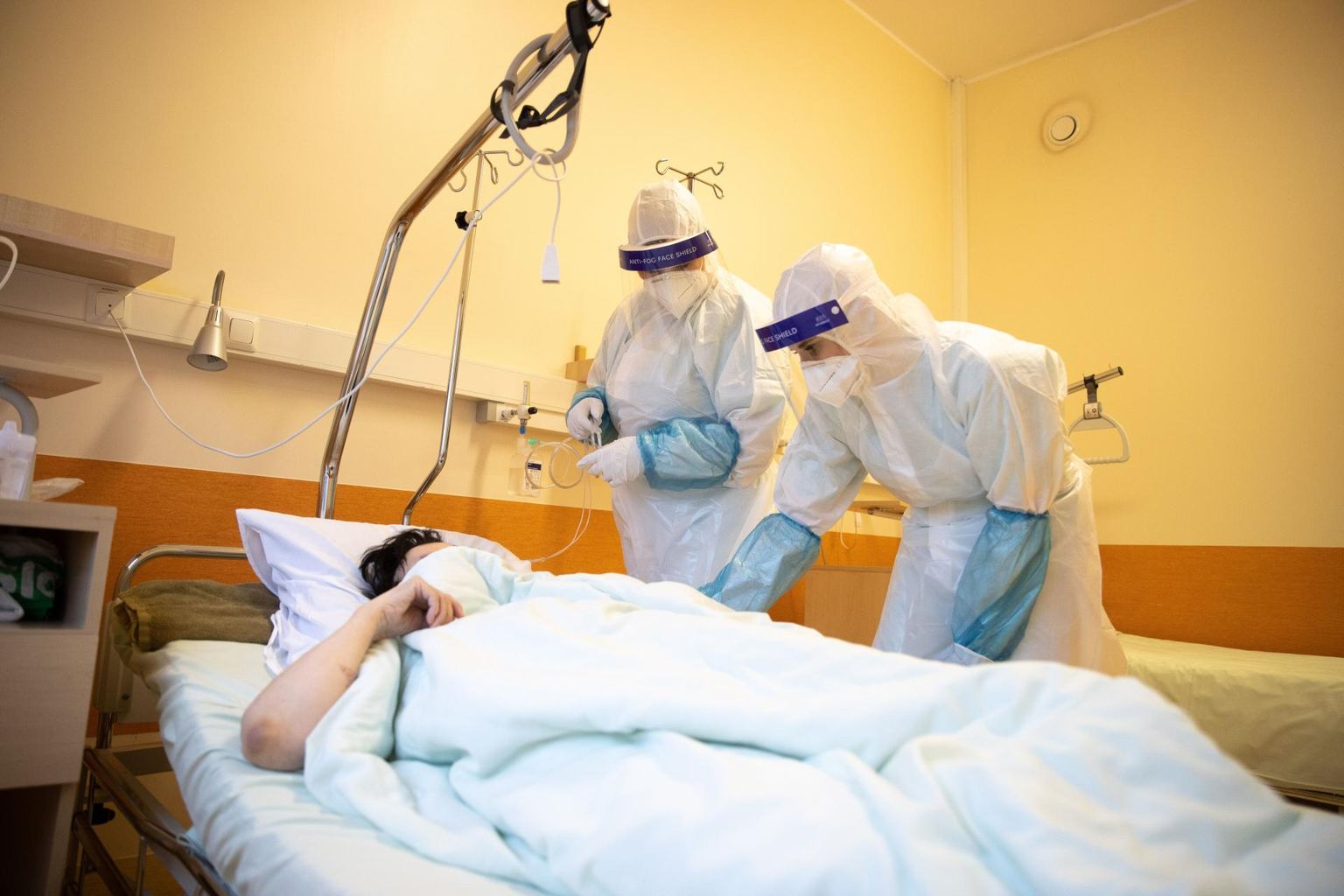 Медработники заботятся о пациенте в Covid-отделении Ида-Таллиннской центральной больницы.
