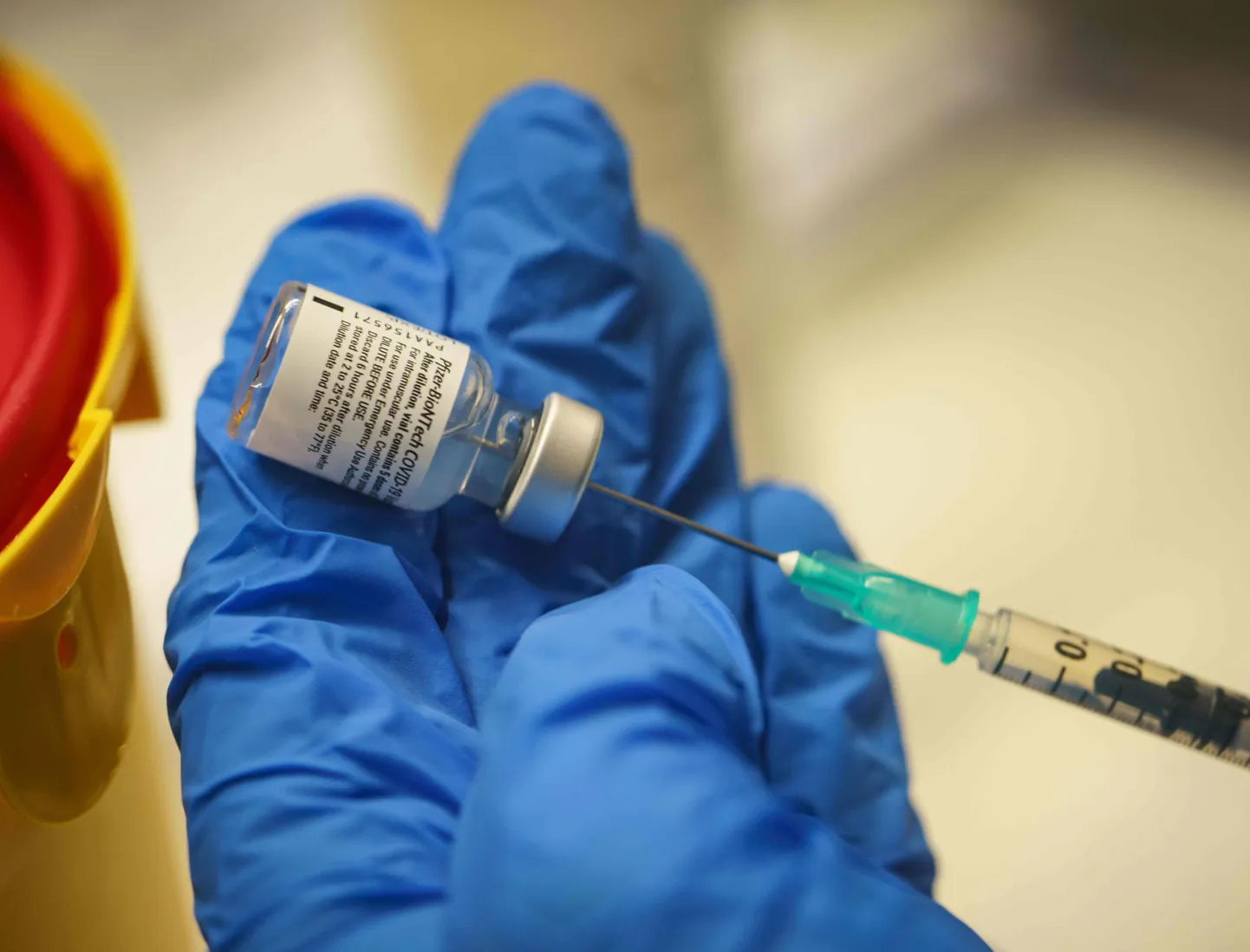 Saksamaa Darmstadti vaktsineerimiskeskuse medtöötaja hoidmas käes Biontech-Pfizer koroonavaktsiini