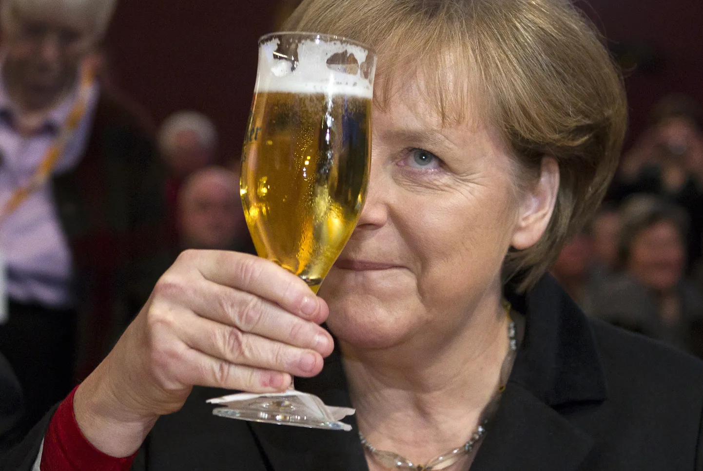 German Chancellor Angela Merkel toasts with a glass of beer during Political Ash Wednesday meeting of the Christian Democratic Union (CDU) in the northern town of Demmin, February 22, 2012.   REUTERS/Thomas Peter (GERMANY - Tags: POLITICS)