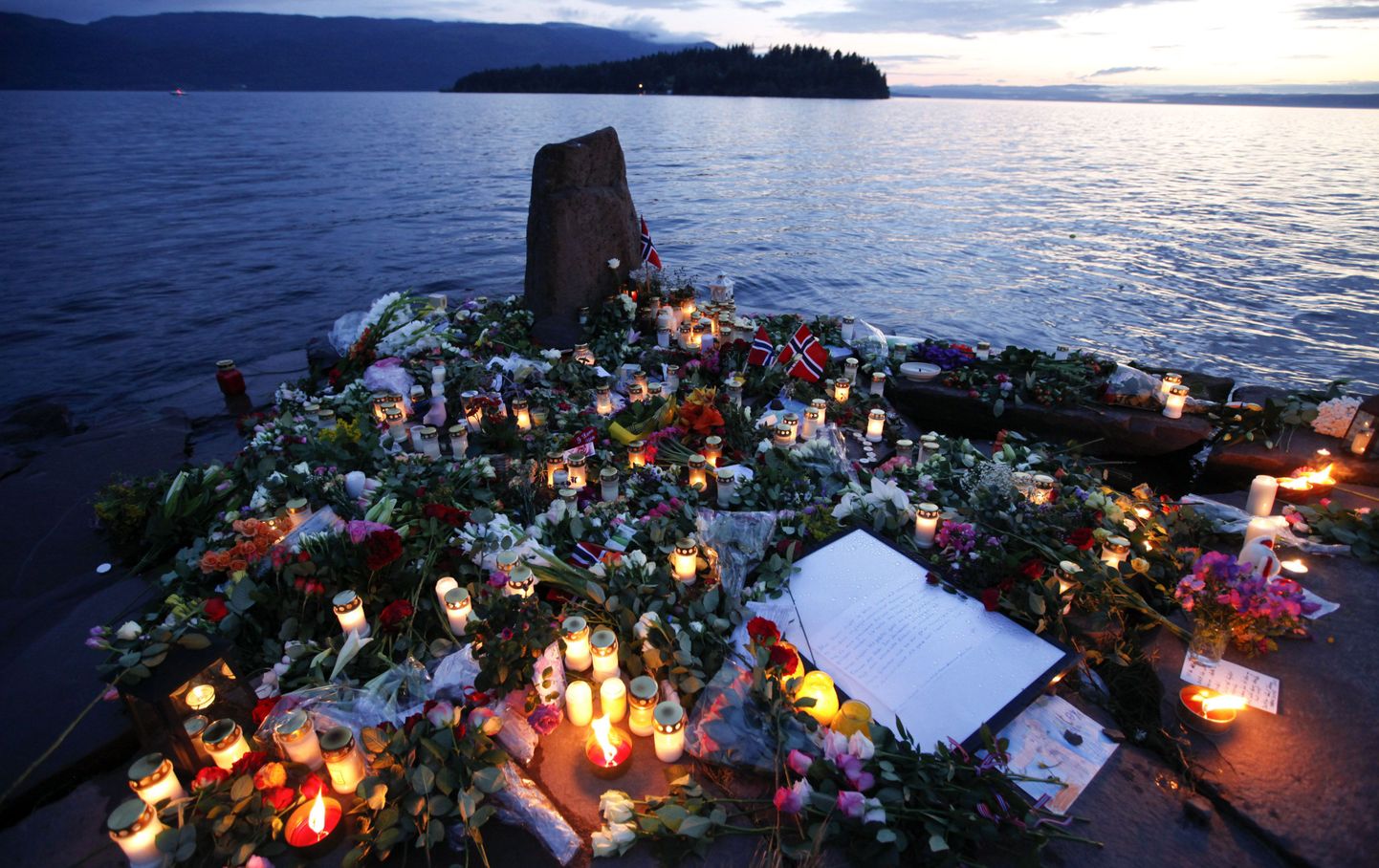 Цветы и свечи в память о погибших на острове Утоя.