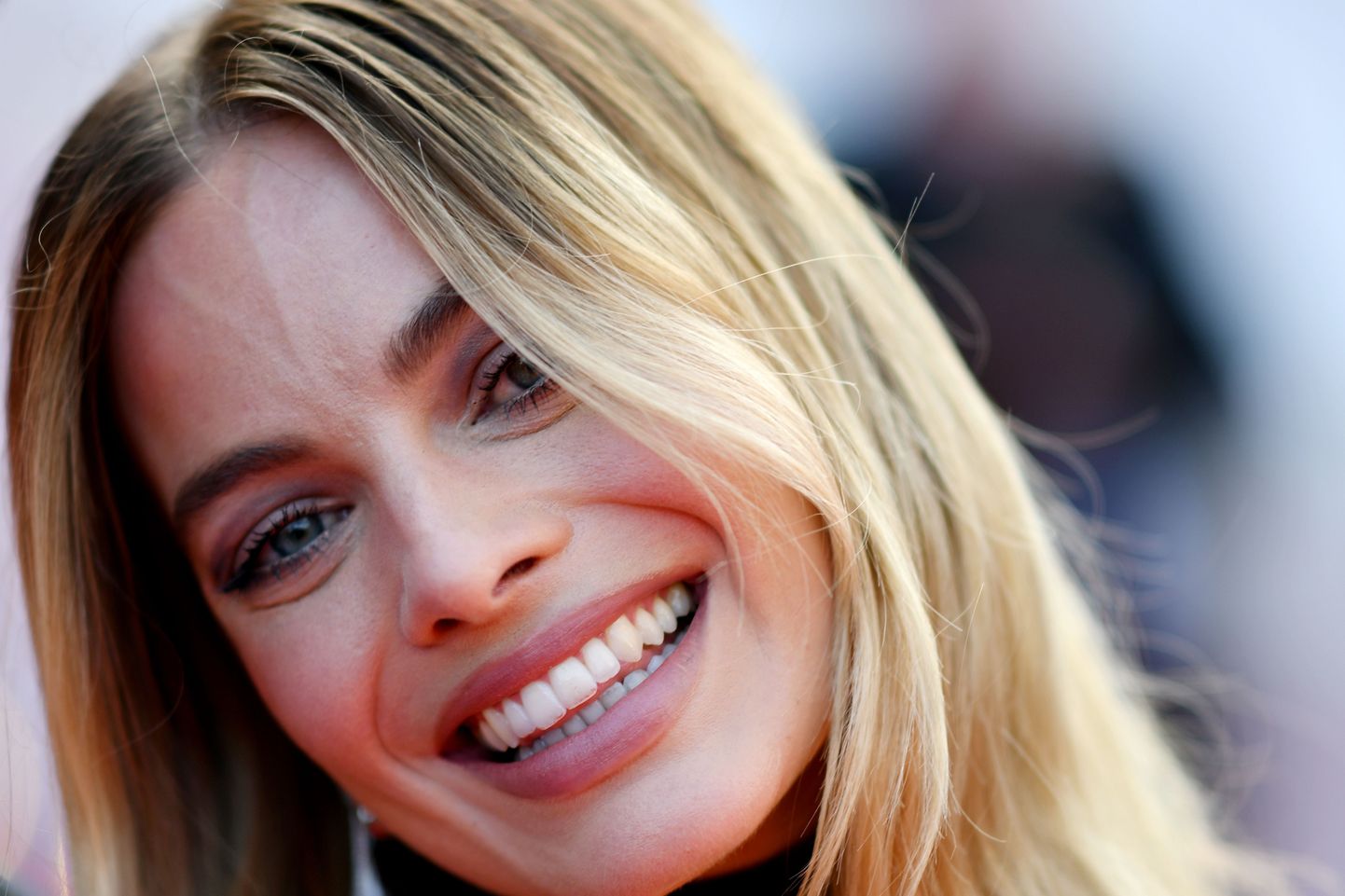 Naeratav Margot Robbie on artiklit illustreeriv