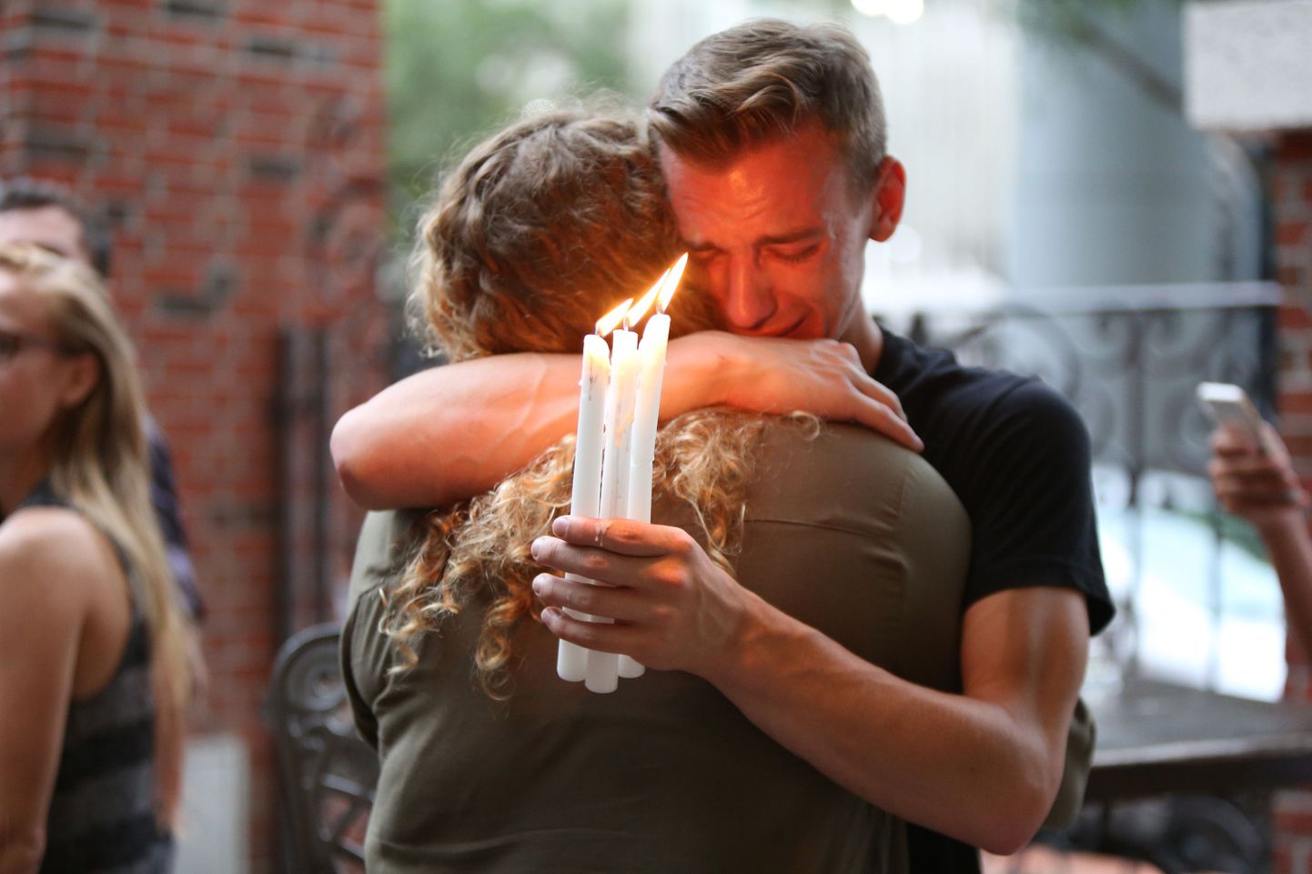 Brett Morian, from Daytona Beach, hugs an attendee during the candlelight vigil at Ember in Orlando, Fla., on Sunday, June 12, 2016. (Photo by Joshua Lim/Orlando Sentinel/TNS) *** Please Use Credit from Credit Field ***