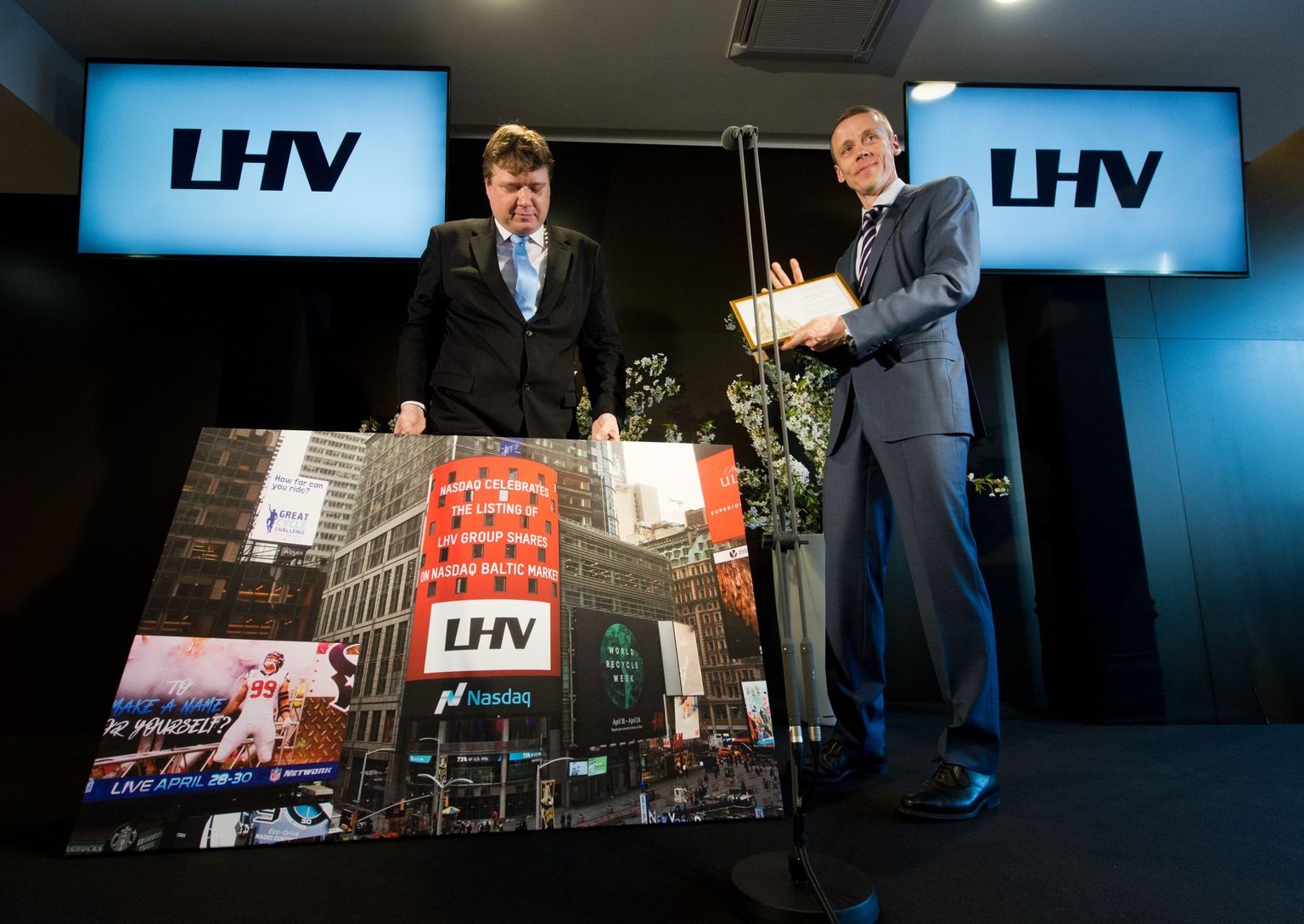 Nasdaq Tallinna juht Rauno Klettenberg (vasakult) andis LHV Groupi juhile Erkki Raasukesele kingitusena üle pildi Nasdaqi börsikeskusest New Yorgis Times Square’il.