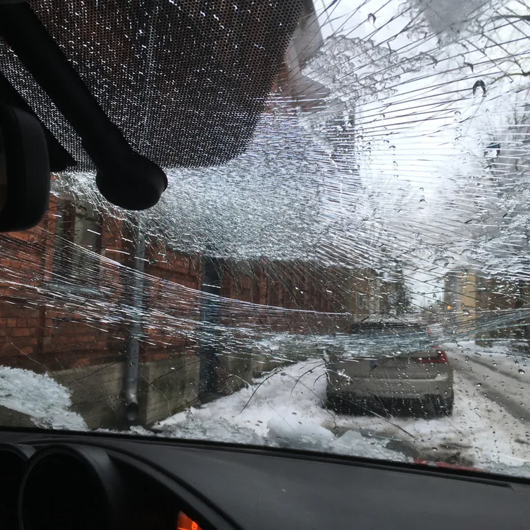 Katuselt kukkunud lume ja jää tõttu purunenud klaas.