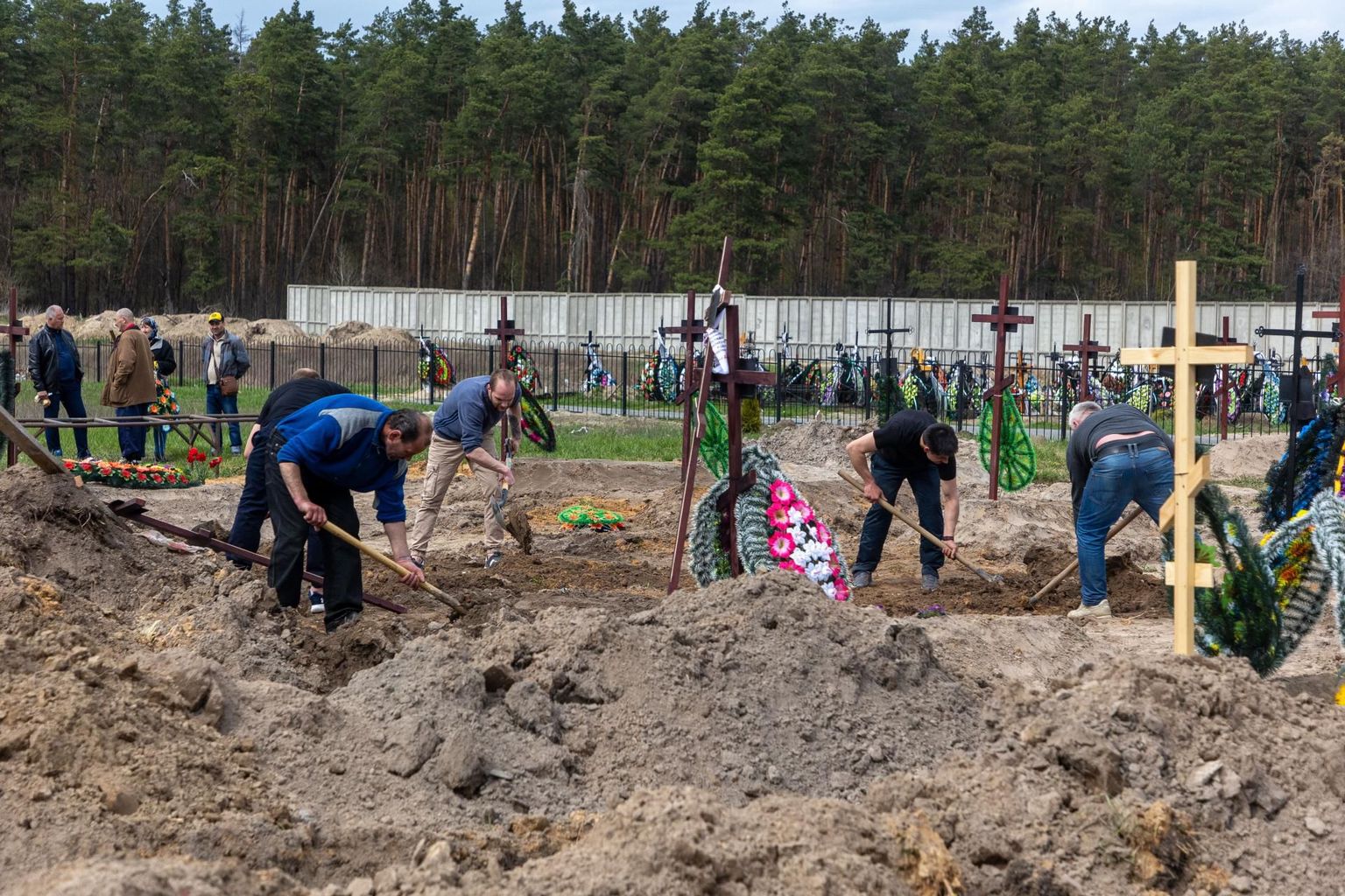 Раскопки захоронения мирных жителей, убитых российскими военными в Буче.